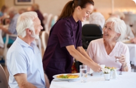 a server smiles while delivering plates to a table
